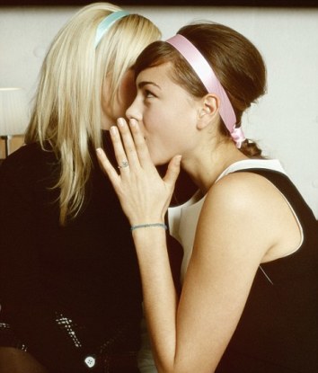 Two Young Women Whispering
